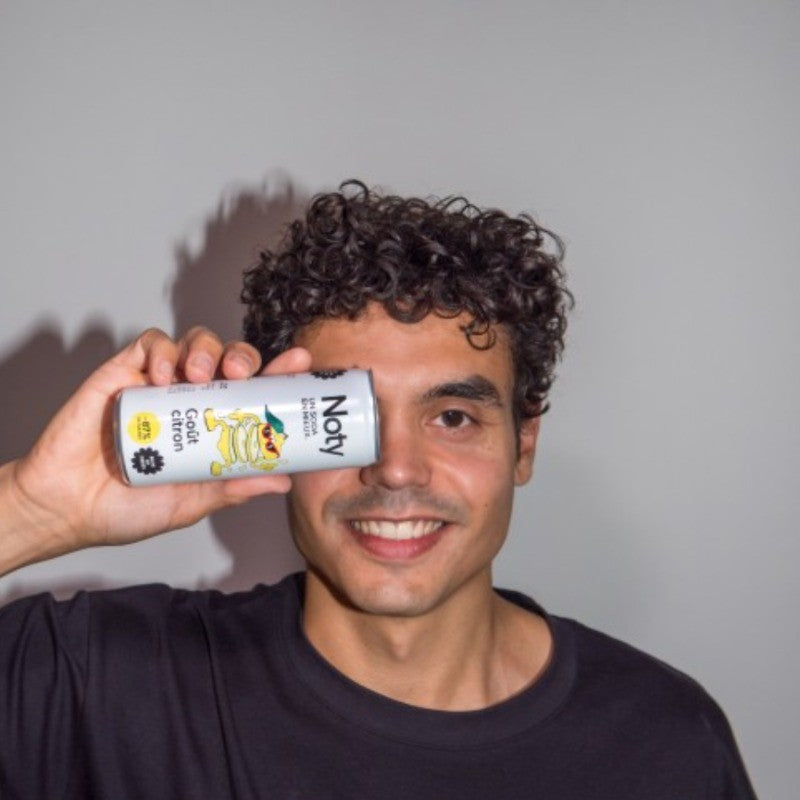 Pierre Reichert, fondateur de NOTY, une canette Citron devant l'œil